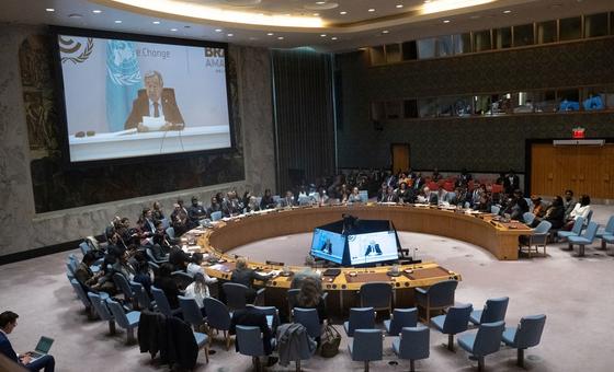 联合国安理会就西非巩固和平问题举行会议的广角镜头。秘书长古特雷斯（屏幕上）通过视频向成员国通报情况。